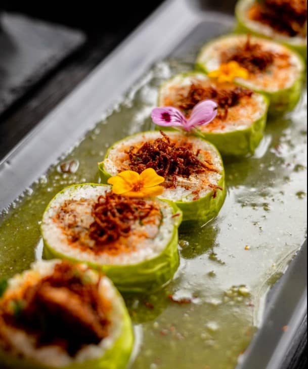Cucumber-wrapped rolls with a crispy topping and flowers